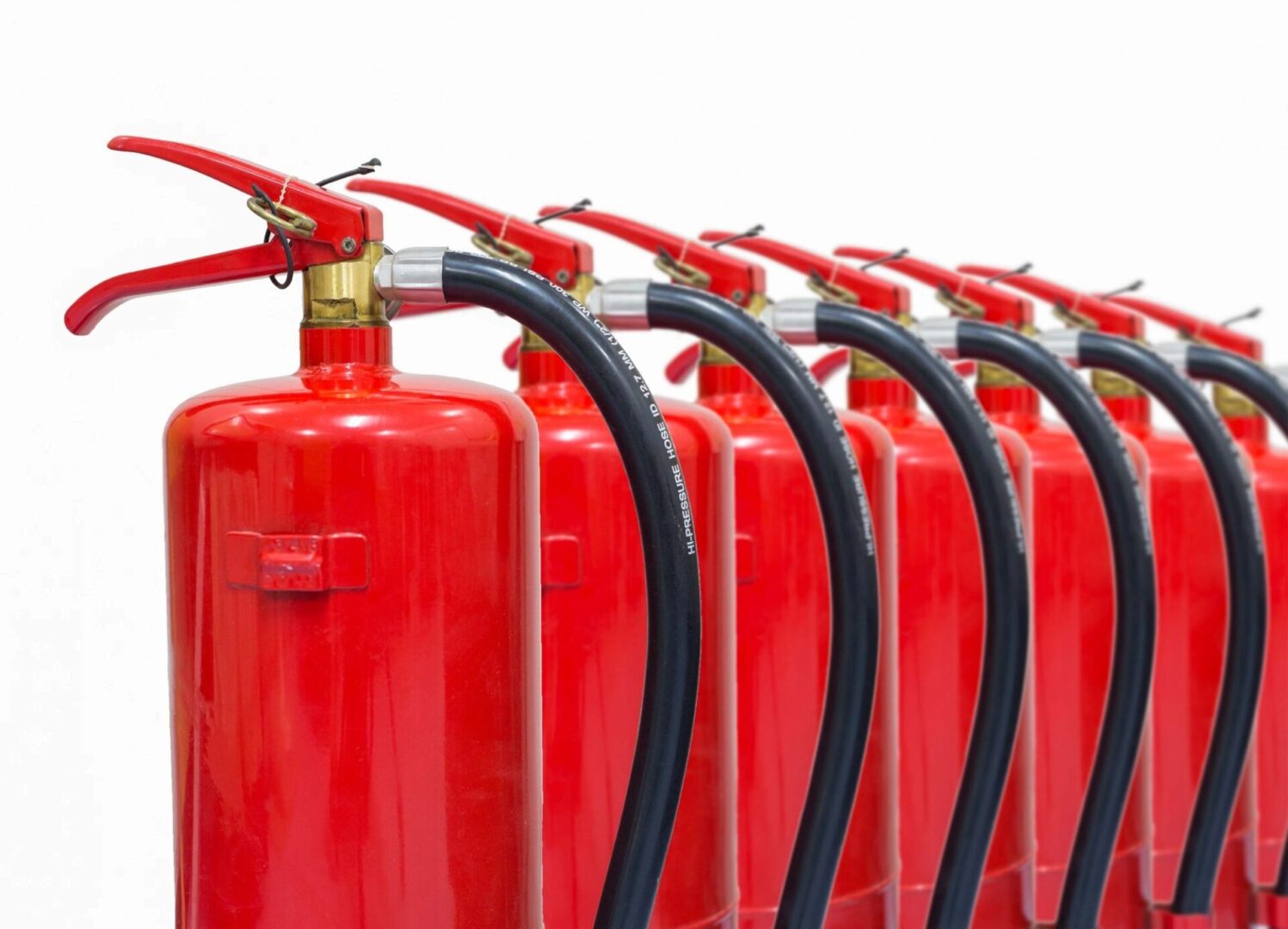 A row of red fire extinguishers with black hoses.