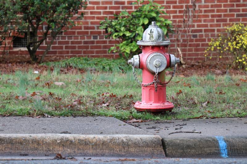 A red and silver fire hydrant on the side of the road.
